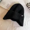 Dettaglio del cappello in maglia nera con paraorecchie e etichetta a fiocco di neve - Taglia unica / Nero