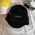 Détail de la broderie Studious et étiquette cheval sur le bonnet en tricot noir - Noir