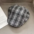 Detailed close-up of a classic black and white checkered newsboy cap on a textured background - One Size / Gray Black Plaid