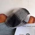 Detail view of retro herringbone wool newsboy cap on vintage leather and denim background - Adjustable / Coffee