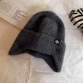 Detail of dark grey plush knit hat with snowflake label and soft fuzzy texture - One Size / Gray
