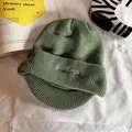 Détail du bonnet en tricot vert avocat avec broderie 'Studious' et texture côtelée - Vert