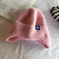 Detail of pink faux mohair knit trapper hat featuring a blue snowflake patch on soft fabric - One Size / Pink