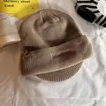 Gros plan détaillé sur casquette en maille kaki avec patch en cuir et broderie hiver - Kaki