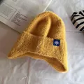 Dettaglio berretto in maglia peluche zenzero con toppa fiocco di neve e trama morbida - Taglia unica / Giallo