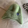Close-up of light green knit earflap hat showing soft faux mink fur and snowflake patch - One Size / Light Green