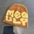 Detail shot of fuzzy knit beanie with yellow MEAGLP lettering on fluffy ginger base - One Size / Earthy Yellow