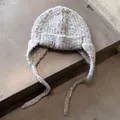 Detail of grey plush knit trapper hat showing loop yarn texture and braided ties - One Size / Light Gray