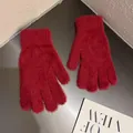 Détail de gants rouges en fausse fourrure montrant la texture douce et les poignets - Rouge