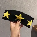 Vue détaillée du bandeau tricoté noir avec trois motifs d'étoiles jaunes en jacquard - Noir + Jaune