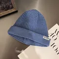 Detailed texture of blue ribbed knit beanie featuring a white NTRX square woven label - M / Blue Denim