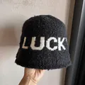 Dettaglio cappello a secchiello in maglia nera con scritta LUCKY bianca e trama spessa - M / Nero