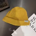 Detail of a ginger yellow ribbed knit beanie with a white NTRX letter patch label - M / Yellow