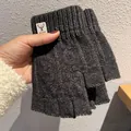 Close-up of dark grey knitted fingerless gloves with a deer logo patch on the ribbed cuff - One Size / Dark Gray