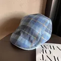 Vue détaillée de la texture en laine à carreaux bleus de cette casquette plate chic - M / Bleu