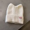 Detailaufnahme der cremefarbenen Katzenohr-Strickmütze mit weicher Mohair-Textur - Beige