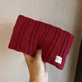 Detail showing deep red ribbed knit fabric texture and minimalist brand label on the headband - Burgundy