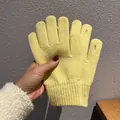 Detail von hellgelben Strickhandschuhen mit gerippten Bündchen und offenen Fingerspitzen - Einheitsgröße / Hellgelb