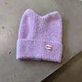 Detailaufnahme der fliederfarbenen Strickmütze mit Katzenohren und weicher Textur - Lila