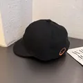 Detalle de gorra negra de visera corta con bordado naranja y textura de sarga - Ajustable / Negro