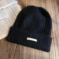 Gros plan sur le bonnet en tricot noir avec texture mohair et écusson en cuir Institute - Taille unique (55-60cm) / Noir