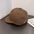 Primer plano del bordado de carita sonriente en la gorra de béisbol de algodón marrón - Ajustable / café