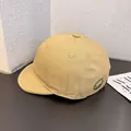 Primer plano detallado de gorra de visera corta caqui con bordado de sonrisa verde - Ajustable / Amarillo Caqui