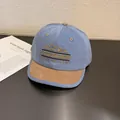 Close-up of the light blue baseball cap featuring mountain embroidery and suede brim detail - Kids (52-54cm) / Blue