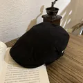 Retro black cotton ivy cap with adjustable metal buckle on a vintage wooden desk - M / Black