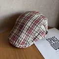 Close-up of a classic red and black plaid newsboy cap on a rustic wooden background - M (55-59cm) / Burgundy Rice Plaid