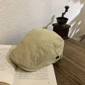 Retro khaki flat cap for women with metal side buckle on a vintage book background - M / Khaki