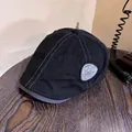 Close-up of black retro flat cap with gray contrast stitching and vintage side patch logo - M (55-59cm) / Black