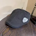 Detail of charcoal black newsboy cap featuring a stitched decorative vintage patch - M (55-59cm) / Gray