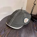 Detail of vintage newsboy cap showing white contrast stitching and embroidered logo patch - M (55-59cm) / Army Green