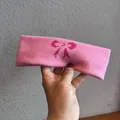 Close-up of pink knitted headband with dark pink bow pattern in soft cotton fabric - Pink
