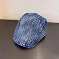 Detailweergave van de lichtblauwe denim textuur en stiksels op een vintage krantenpet - M (55-59cm) / Middelblauw