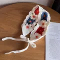 Nahaufnahme des handgefertigten Häkel-Stirnbands mit Blumenmuster und Wellenrand-Detail - Rot Navyblau