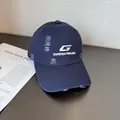Detailed view of white letter G embroidery and distressed holes on navy blue baseball cap - Adjustable / Navy Blue