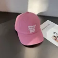 Detail of white embroidery on a dusty rose baseball cap with curved brim and cotton texture - Adjustable / Raspberry Pink