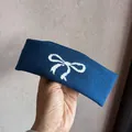 Nahaufnahme eines dunkelblauen Stirnbands mit weißem Strickschleifenmuster und Textur - Dunkelblau