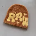 Detail der Textur von dunkelbrauner Kunstpelz-Beanie mit gelber RRW-Stickerei - Gelb