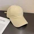 Détail d'une casquette en velours côtelé beige avec broderie blanche et coutures soignées - Réglable / Poche zippée