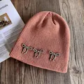 Détail du bonnet en tricot orange avec trois nœuds décoratifs en perles argentées - M(54-58cm) / Bleu foncé