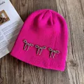 Détail du bonnet en maille côtelée rose avec nœuds perlés argentés sur bois - M(54-58cm) / Rose rouge