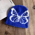 Nahaufnahme einer flauschigen königsblauen Beanie mit weißem Schmetterlingsmuster - M (54-58cm) / Saphirblau