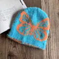 Detail der blauen Webpelz-Beanie mit großem orangefarbenem Schmetterlings-Jacquardmuster - M (54-58cm) / Seeblau