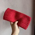 Nahaufnahme des handgestrickten roten Stirnbands mit dicker Wollwebstruktur - Rot