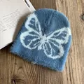 Nahaufnahme der blauen Strickmütze aus Nerzimitat mit weißem Schmetterlingsmuster - M (54-58cm) / Dunkelblau