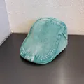 Dettaglio del berretto piatto in denim verde menta con trama in twill lavato e cuciture - M (56-60cm) / Verde menta