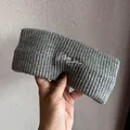 Nahaufnahme des grauen Strickstirnbands mit weißer Stickerei auf grobem Wollmaterial - Grau